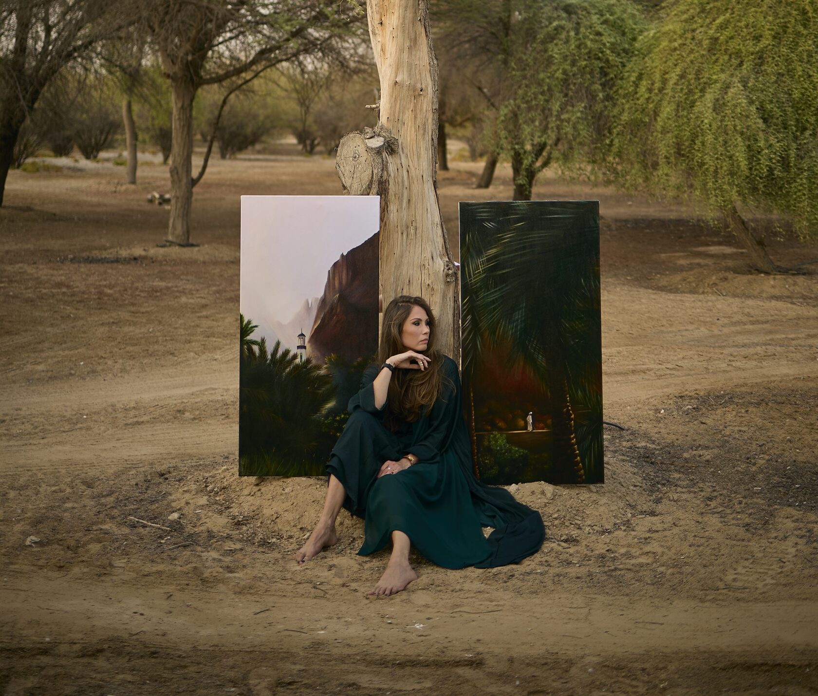 Artist seated under a tree with two paintings